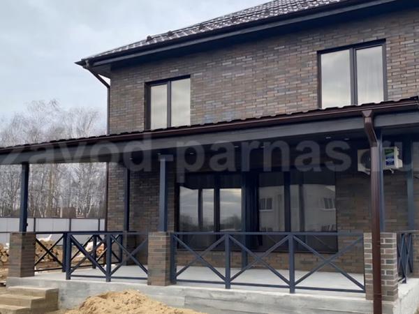 Терраса с кирпичными колоннами и металлическими перилами-крестовинами